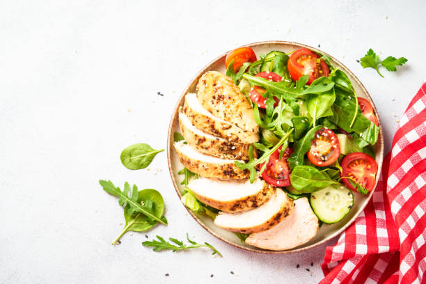 istock Green salad with grilled chicken meat at black table. 2188189980