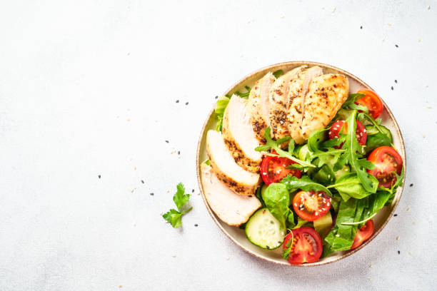 istock Green salad with grilled chicken meat at black table. 2188189985