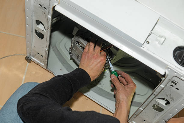 istock A repairman fixes a broken washing machine at home. 2188190008