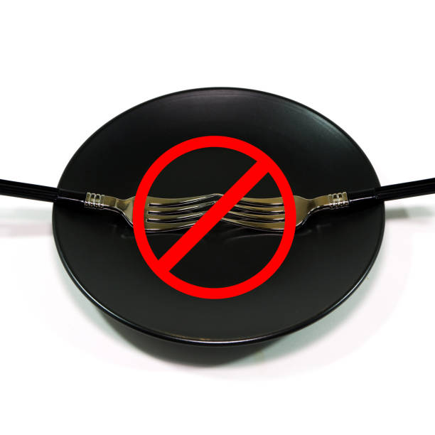 istock Fork set on black plate with warning sign on foreground closeup view 2188191085