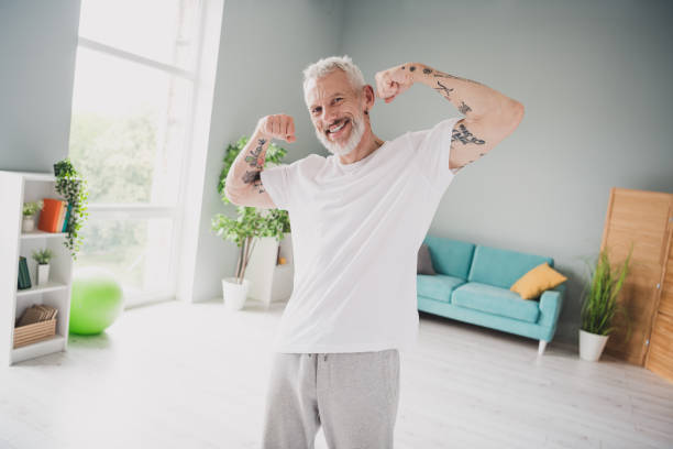 istock Energetic senior man flexing muscles with confidence in a bright home interior showcasing active lifestyle and fitness 2188192272
