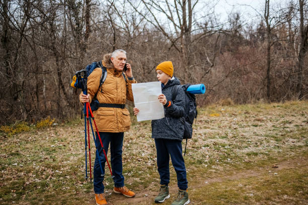 istock Teenager boy enjoying hiking with father in nature on weekend looking for direction using map 2188192436