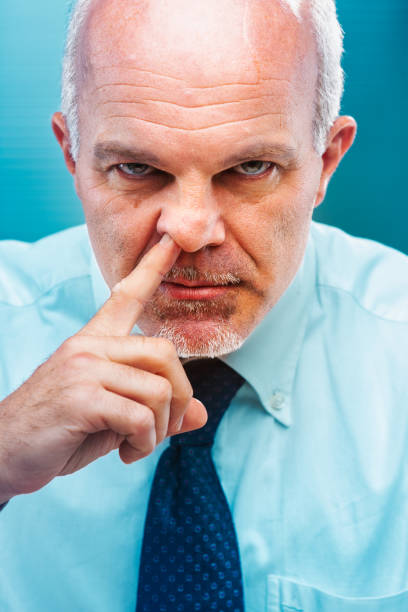 istock Mature businessman picking nose with finger 2188192660