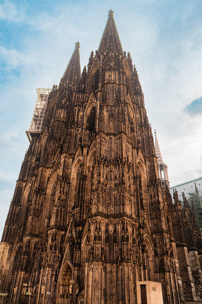 Magnificent Gothic cathedral tower set against a vibrant blue sky, highlighting architectural beauty and detailed stone craftsmanship. Ideal for themes of history, architecture, and cultural heritage