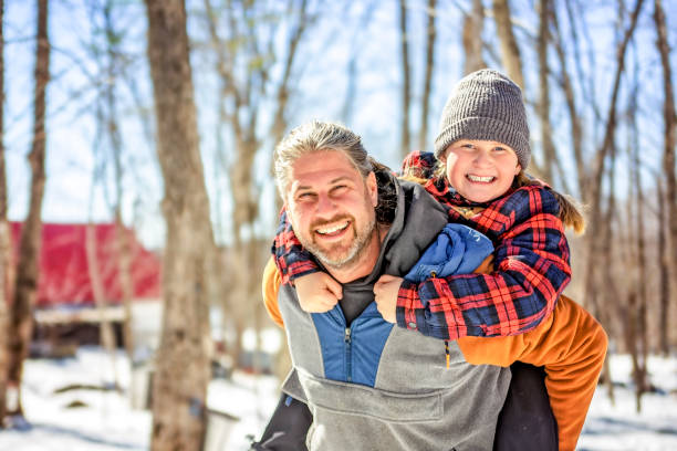 A family close to a maple shack having fun together