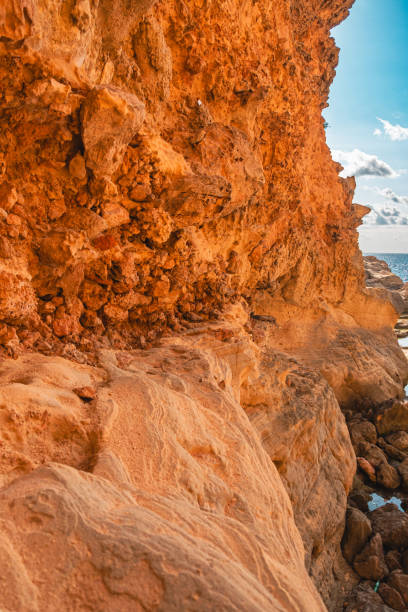 istock Stunning Rocky Cliffside View with Dramatic Orange Textures and Ocean Horizon Under a Bright Blue Sky 2188198236