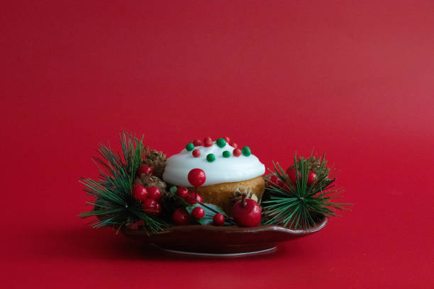 Christmas Cup Cake bedded red berries and green fir on Red background