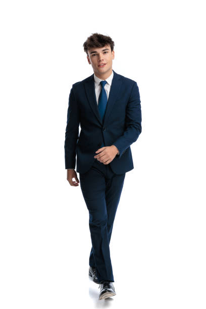 istock happy young man in navy blue suit walking and smiling 2188202592