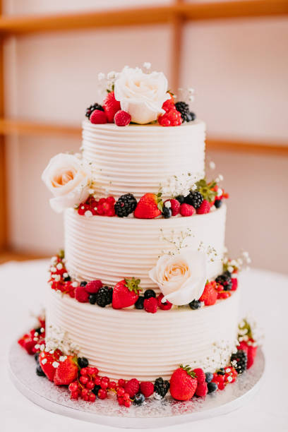 istock Festive three-tiered white cream wedding cake elegantly garnished with red forest berries 2188203158