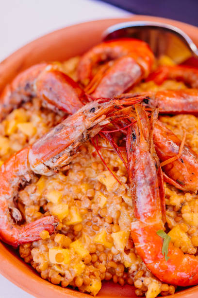 istock Flavorful yellow lentil paella with large langoustines elegantly served in a rustic terracotta bowl 2188203222