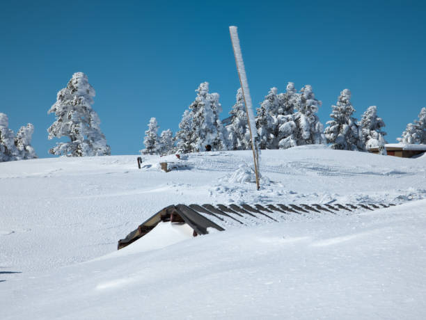 istock Mountain hut almost completely buried by deep, drifting snow on a clear winters day (Yokoteyama, Japan) 2188208770