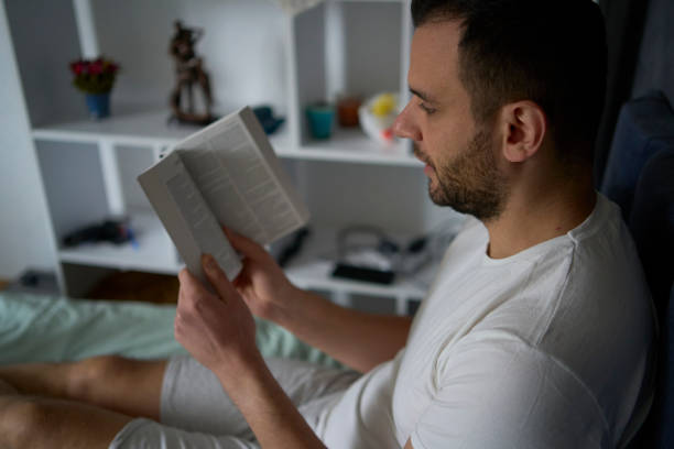 istock 30-year-old man reads the Bible and prays in bed, morning routine 2188209112