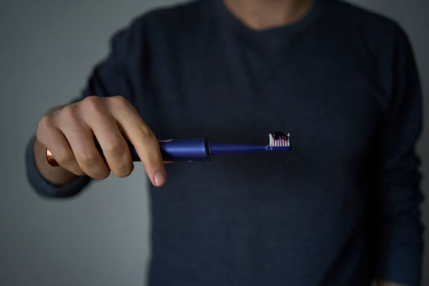 istock A 30-year-old man brushes his teeth with purple toothpaste using an electric toothbrush 2188209236
