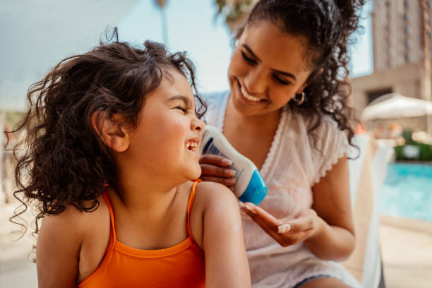 istock Mother putting sunscreen on her daughter before going into the pool 2188210343