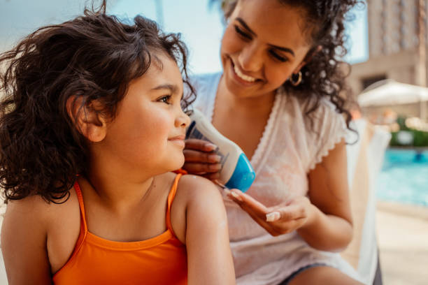 istock Mother putting sunscreen on her daughter before going into the pool 2188210344