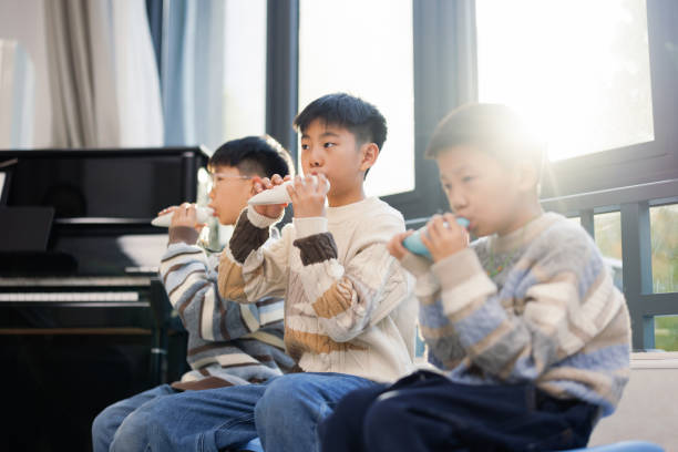 Several elementary school students are studying in the music classroom stock photo