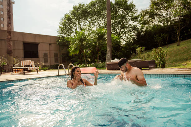 istock Couple jumping into pool at luxury hotel 2188211557