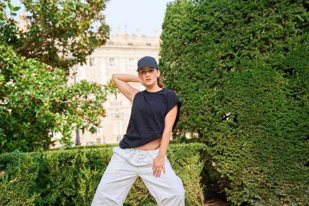 Young woman posing in a garden with lush greenery