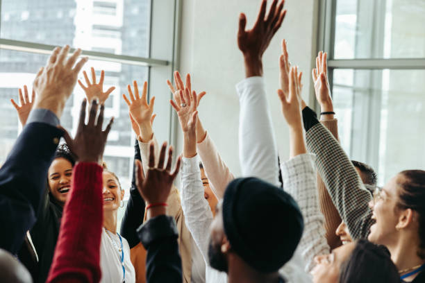 istock Engaged team with hands raised celebrating success in a modern office environment, showcasing enthusiasm and collaboration. 2188214428