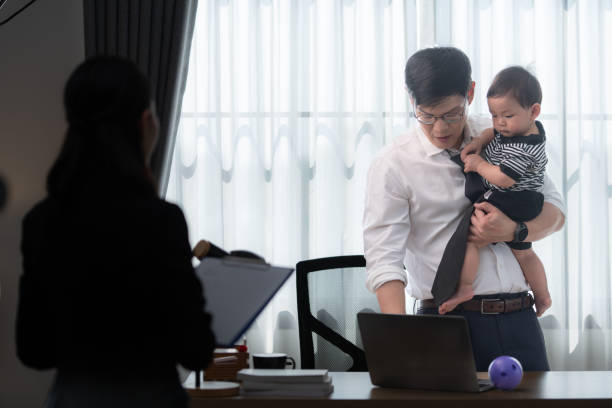 istock A business father assigns work to his secretary, while also taking care of his child while working 2188215949