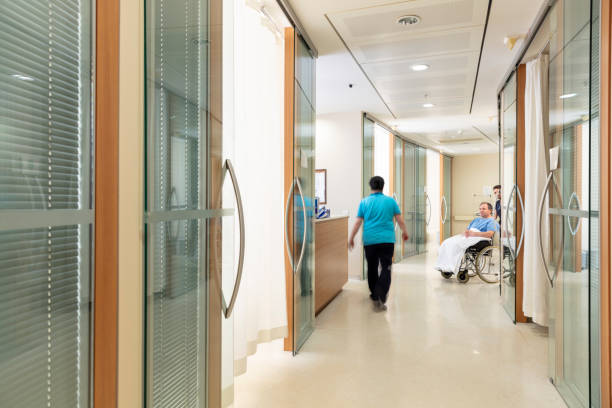 istock Nurse pushing patient in wheelchair down corridor 2188217991