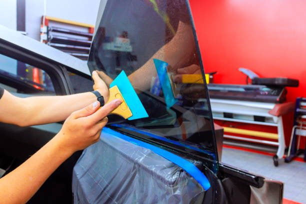 istock Car window tinting process in workshop with skilled technician applying film 2188220416