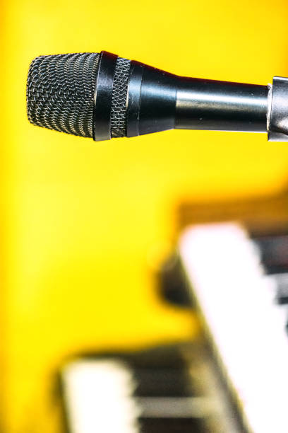 Condenser microphone on shiny black background.
