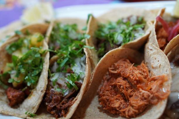 istock typical Mexican food. Tray with assorted tacos garnished with lime and cilantro 2188223325