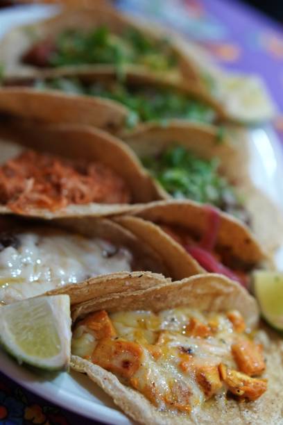 istock typical mexican food. tray with assorted tacos garnished with lime and cilantro. 2188223350
