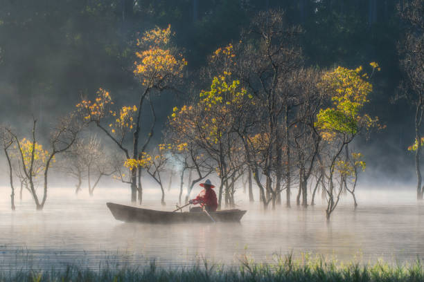 Fisherman in Tuyen Lam lake in a foggy morning, Da Lat city, Lam Dong province, central high lands Vietnam