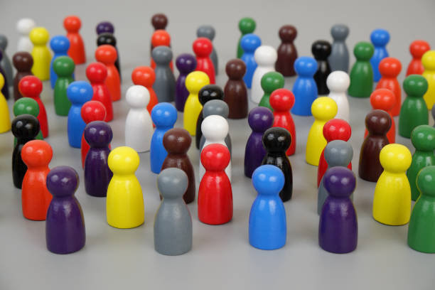 istock Many different colored wooden figures standing close to each other on gray background. 2188226450