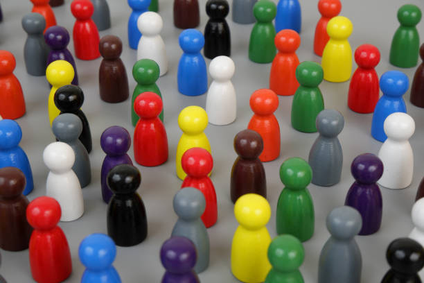 istock Many different colored wooden figures standing close to each other on gray background. 2188226598