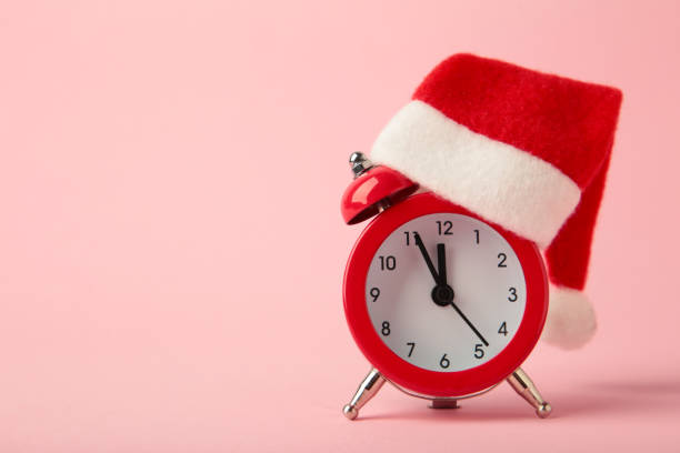 istock Red alarm clock with Christmas Santa hat on pink background. Top view. 2188227769