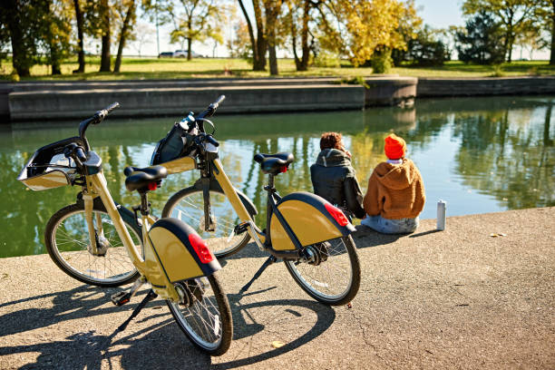 istock Friends sitting at water’s edge in fall sunshine 2188229410