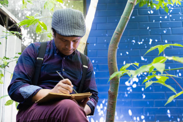 man sitting under the trees writes poetry