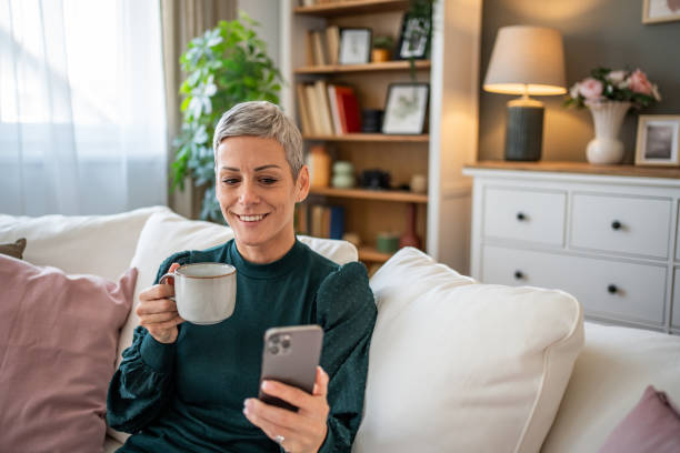istock Short-haired woman connecting with friends via video call while relaxing on the sofa 2188234713