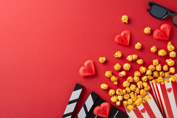 istock Popcorn spills from containers with heart decorations on a red background, perfect for a romantic movie night. Sunglasses and clapboards add a cinema vibe to this Valentine's Day concept 2188235940