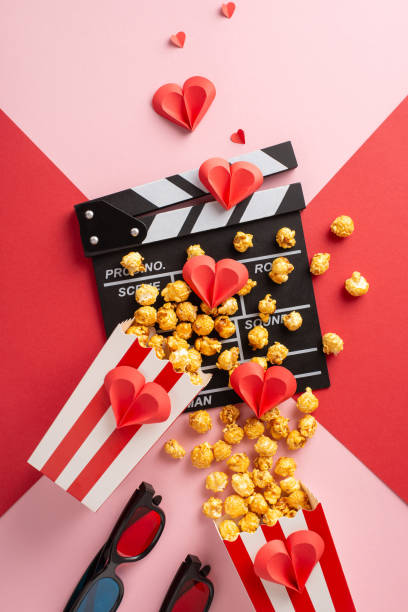 istock A vertical vibrant setup featuring popcorn, a clapperboard, and paper hearts symbolizing love. Ideal for illustrating romantic movie nights or Valentine's Day celebrations 2188235948