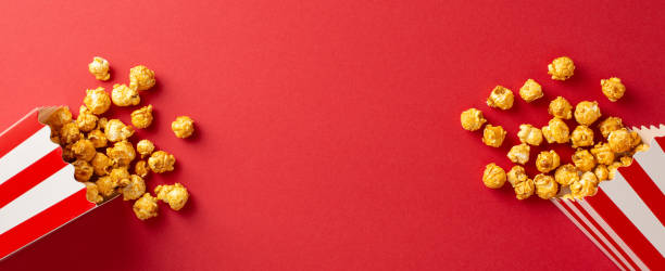 istock Scattered popcorn from striped boxes on a vivid red background, symbolizing a fun movie night experience or celebration 2188235949