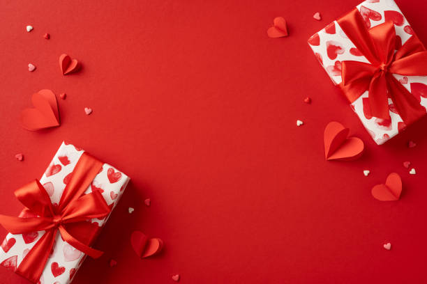istock A vibrant red background featuring two beautifully wrapped gift boxes with heart patterns, surrounded by scattered heart decorations. Perfect for conveying love and Valentine's Day celebrations 2188236009