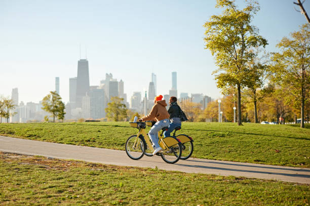 istock Eco-friendly women cycling through Chicago public park 2188236147