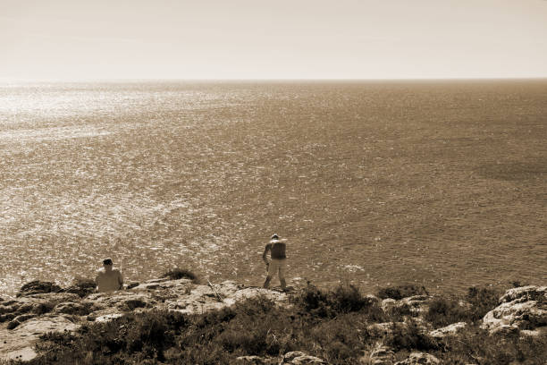 Grandfather carrying his grandson on shoulder on the beach