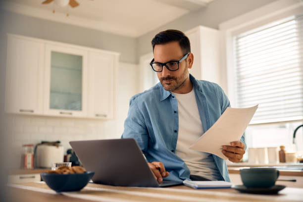 istock Mid adult man going over home finances while using laptop at home. 2188239119