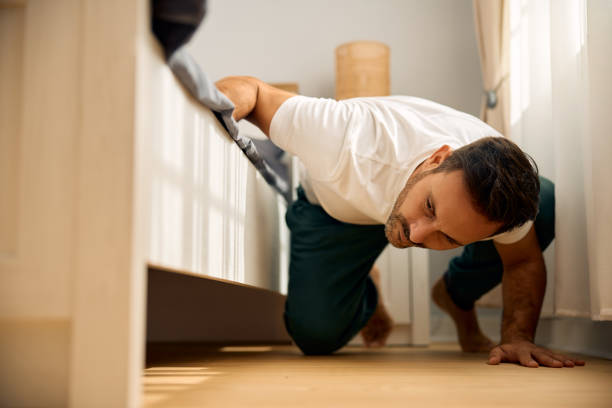 istock Mid adult man searching for something below his bed. 2188240047