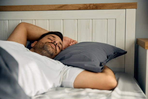 istock Serene man sleeping on a bed at home. 2188240180