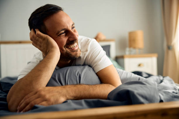 istock Happy man relaxing on his bed in the morning. 2188240195