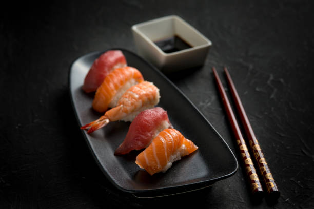 istock sushi with chopstick over black stone 2188241036