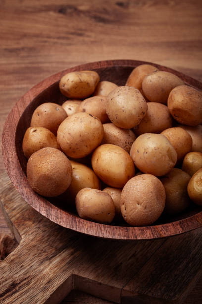 istock Freshly harvested small potatoes displayed in a rustic wooden bowl on a wooden surface 2188244321