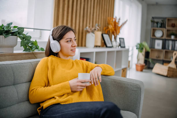 istock Woman enjoying tea sitting on the sofa 2188246213