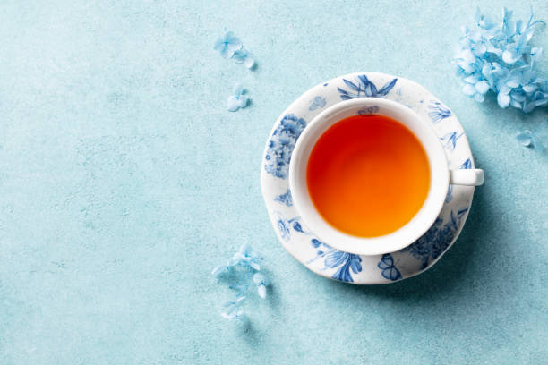 istock Cup of black tea with flowers. Blue background. Copy space. Top view. 2188247519